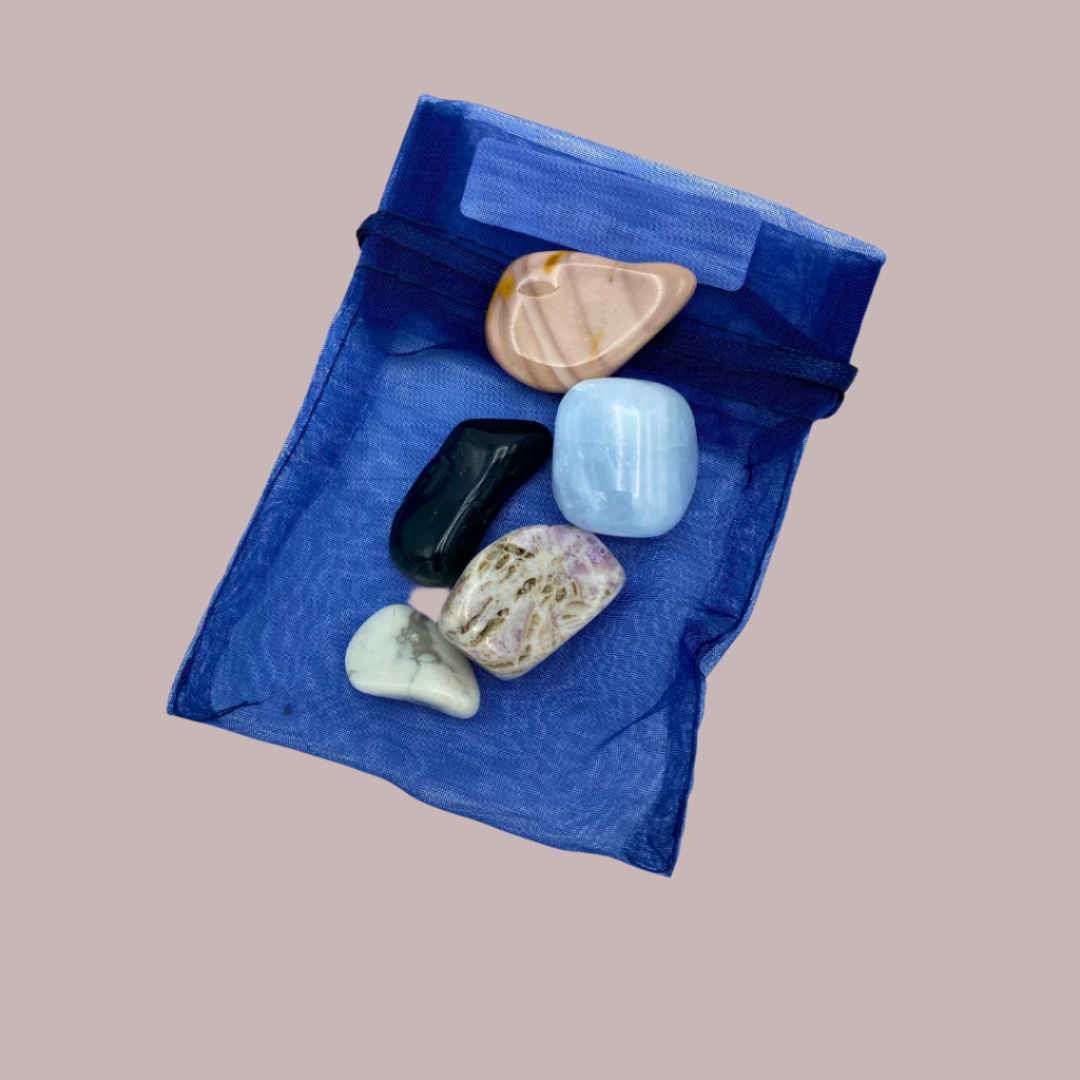 A selection of 5 polished gemstones arranged on a blue bag