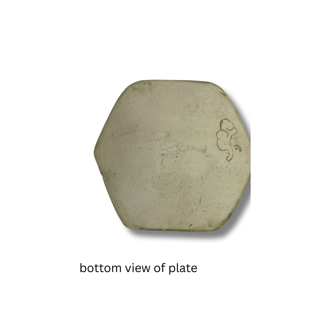 bottom view of A medium-sized, hand-crafted, cream and green floral trinket dish on a white background.