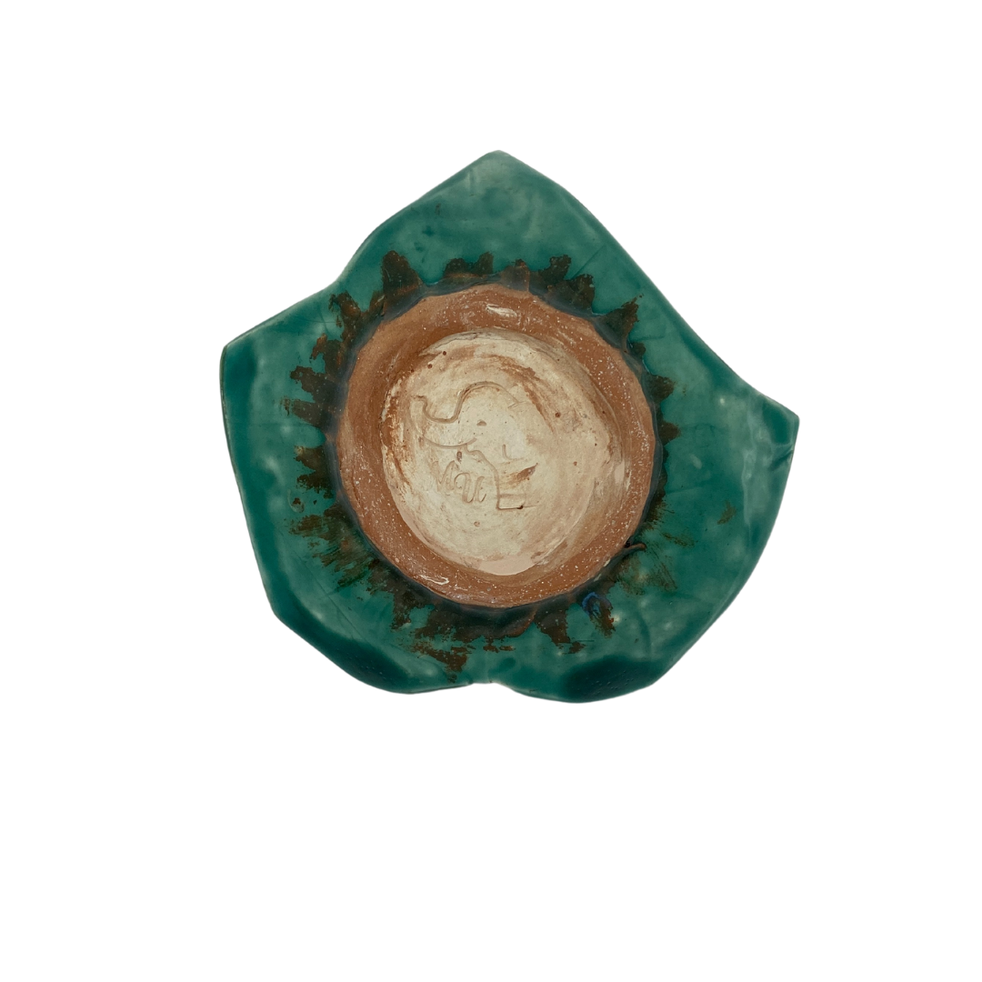 Bottom view of A hand-crafted green leaf-shaped trinket dish on a white background.