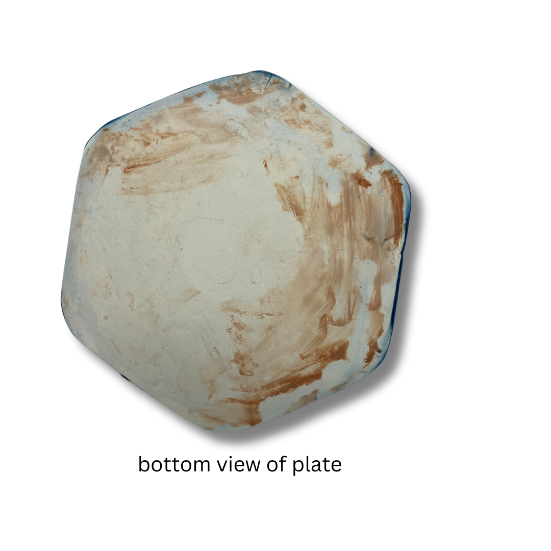 bottom view of of A hand-crafted blue hexagon trinket dish on a white background.