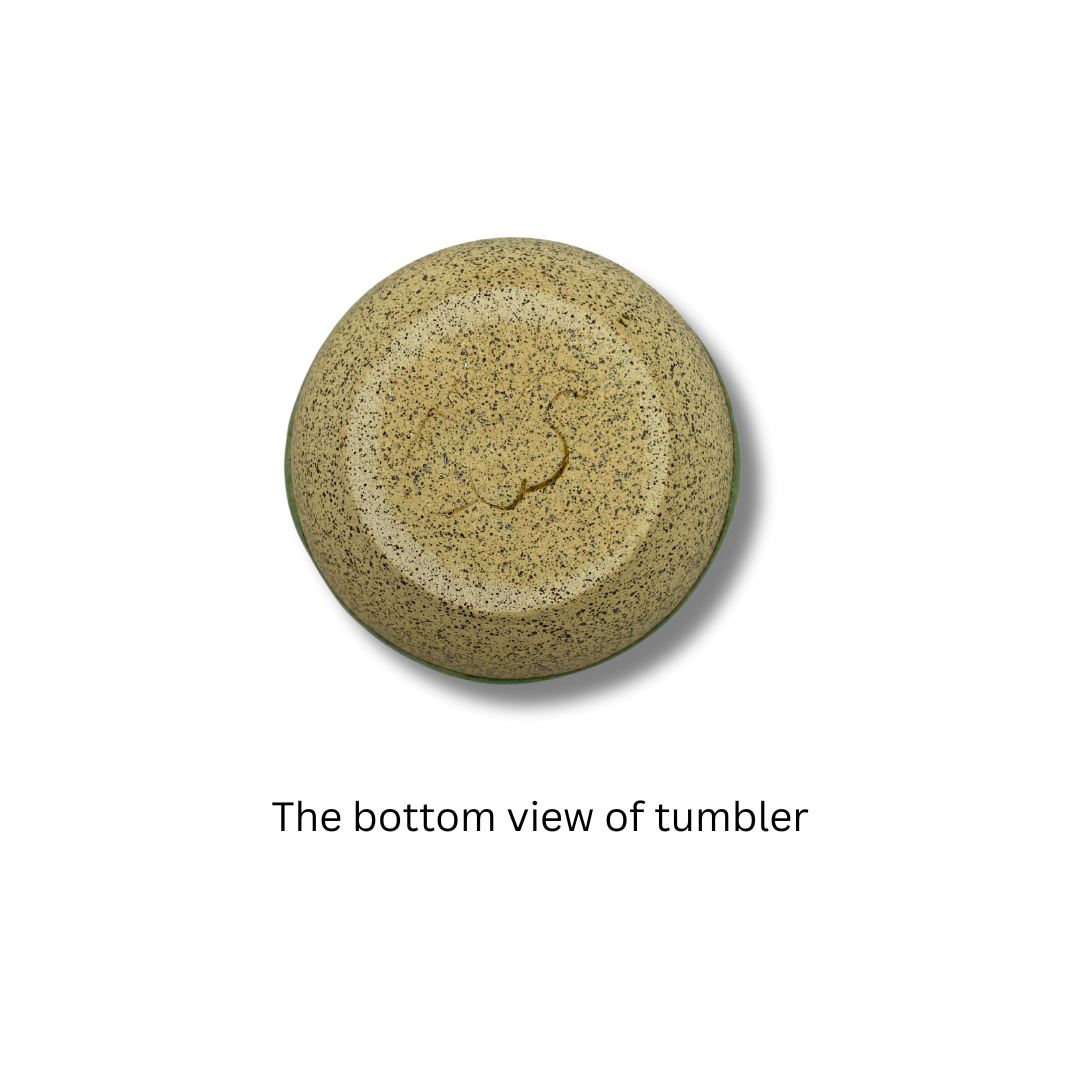 Bottom view of A green ceramic mushroom-shaped tumbler on a white background.