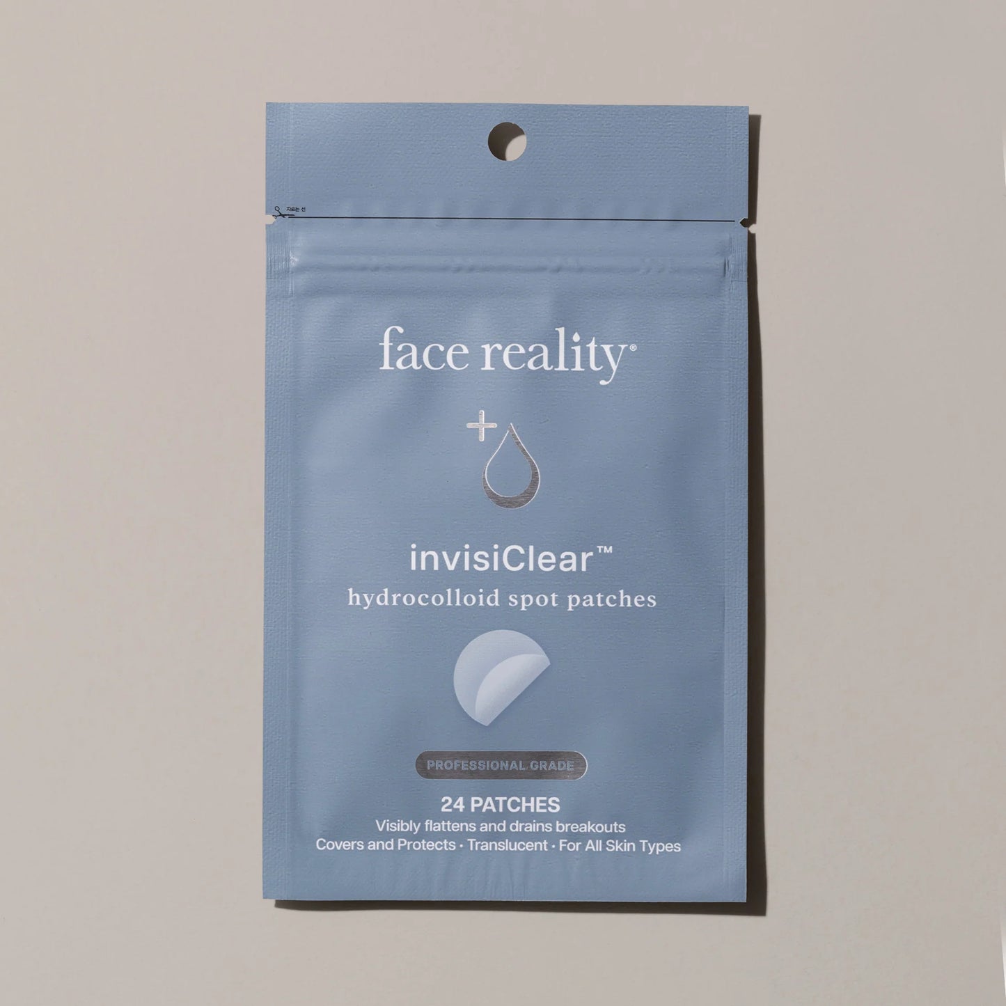 Blue package of face reality invisiClear hydrocolloid spot patches on a beige background