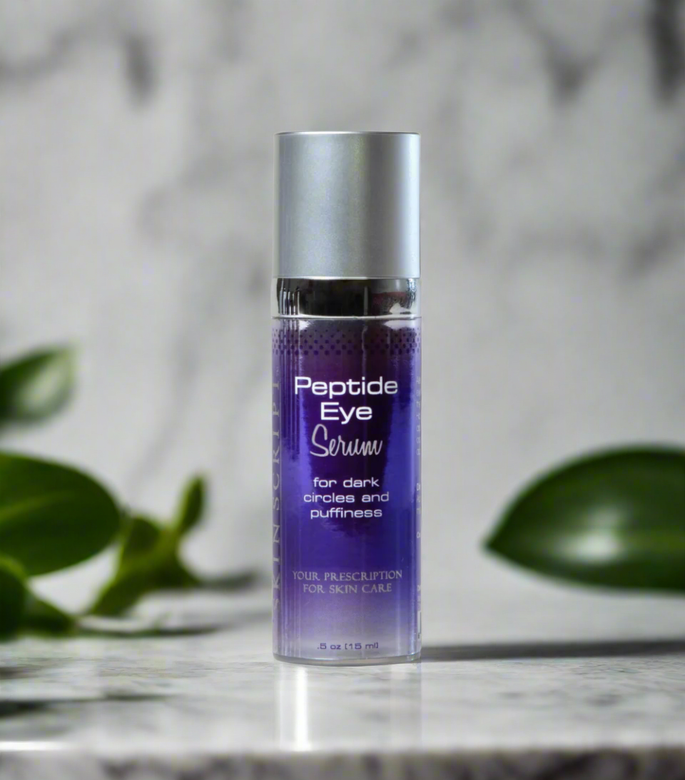 A bottle of SKINSCRIPTS Peptide Eye Serum positioned on a marble surface with a leafy background, indicating a skincare product designed for the eye area.