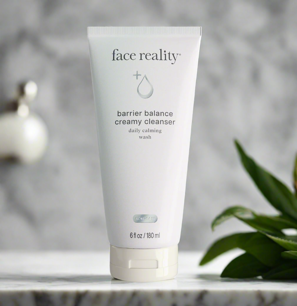 A tube of Face Reality Barrier Balance Creamy Cleanser placed on a surface with a plant in the background.