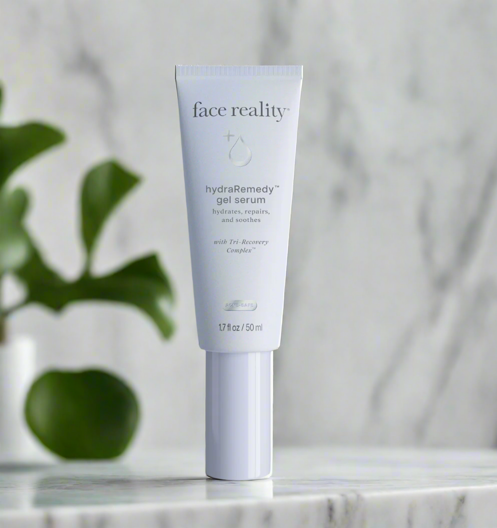 A tube of Face Reality hydraRemedy Gel Serum placed on a marble surface with a plant in the background.