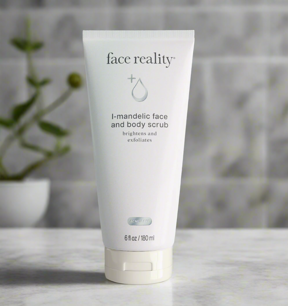 A tube of Face Reality L-Mandelic Face and Body Scrub placed on a surface with a plant in the background.