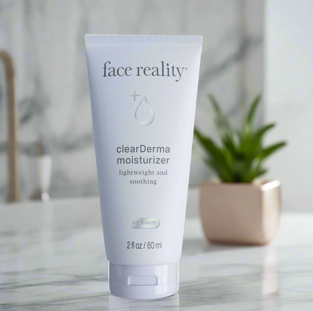 A tube of Face Reality clearDerma Moisturizer placed on a bathroom countertop with a plant in the background.