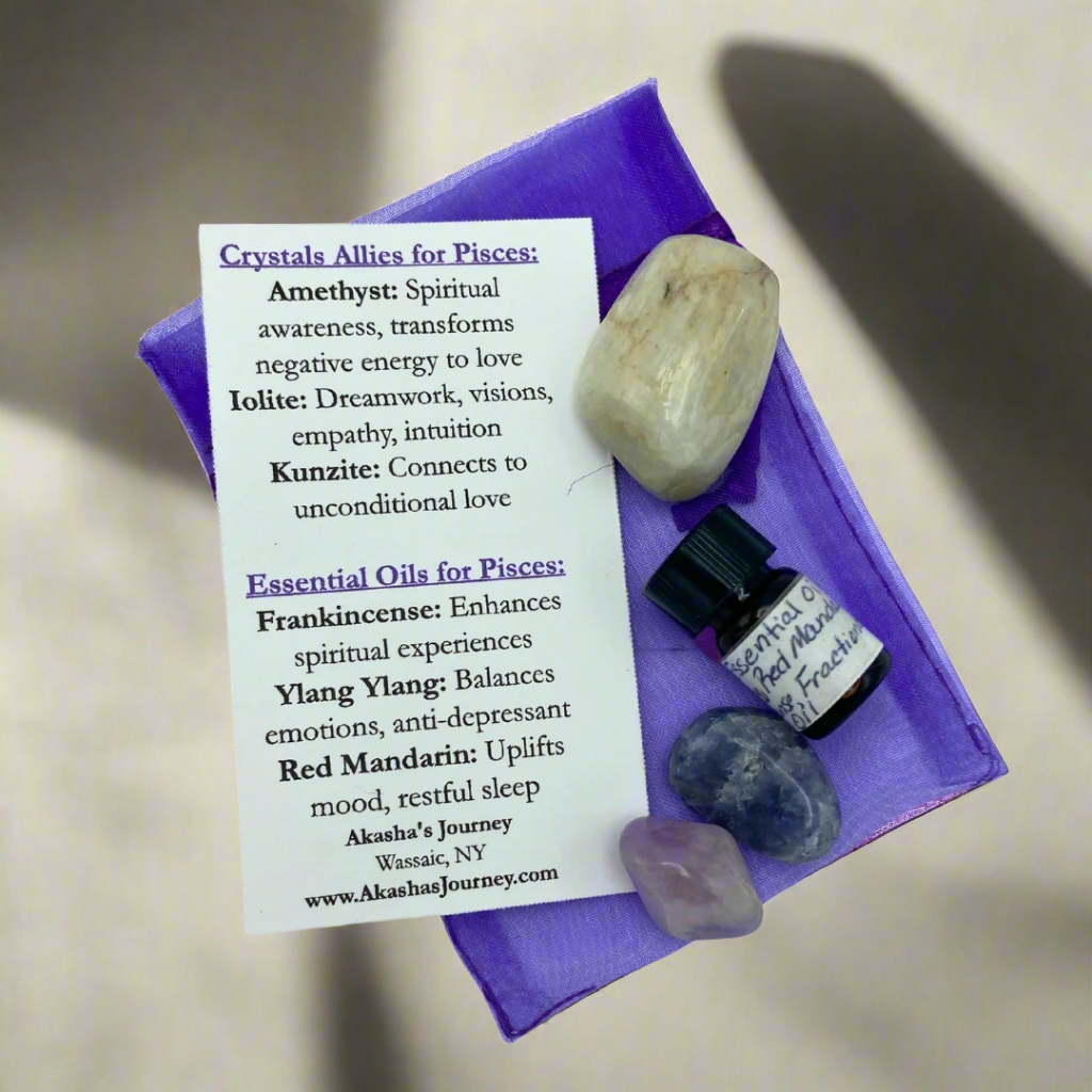 A collection of crystals and essential oils arranged on a purple surface under the lighting, with descriptive cards detailing the properties of each item for a Pisces Zodiac theme.