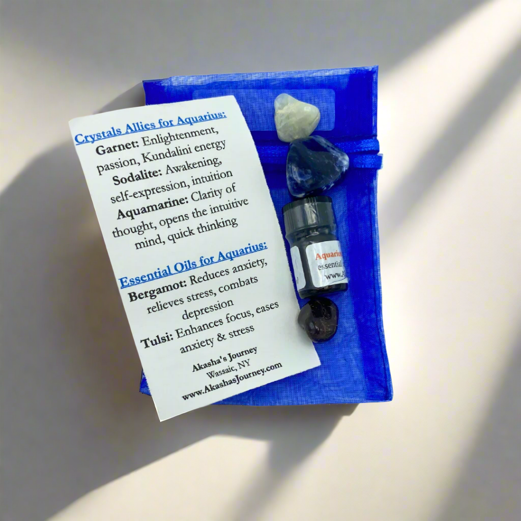 A blue bag containing a selection of crystals and essential oils labeled for Aquarius zodiac sign, along with a card detailing the crystal and essential oil properties.