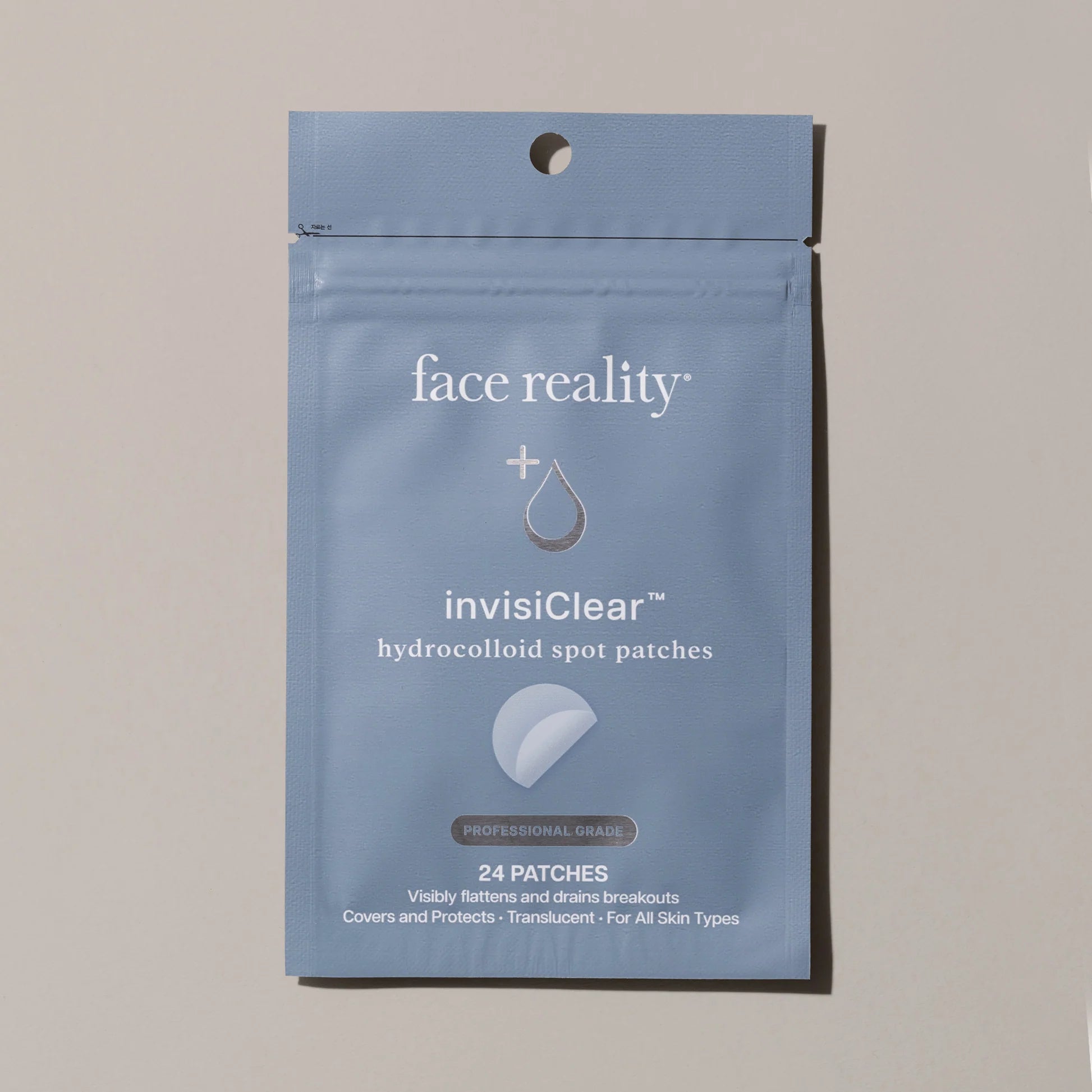 Blue package of face reality invisiClear hydrocolloid spot patches on a beige background