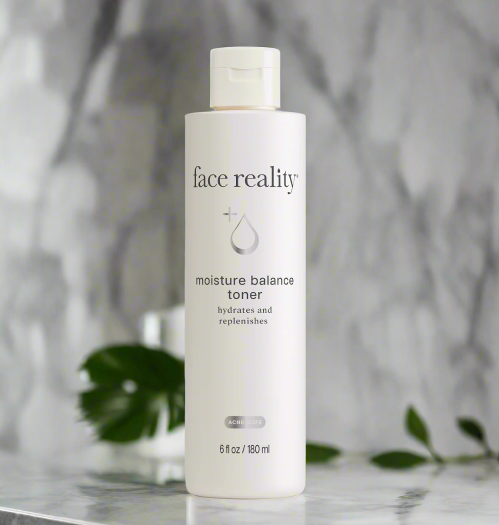 A bottle of Face Reality Moisture Balance Toner placed on a marble surface with a plant in the background.