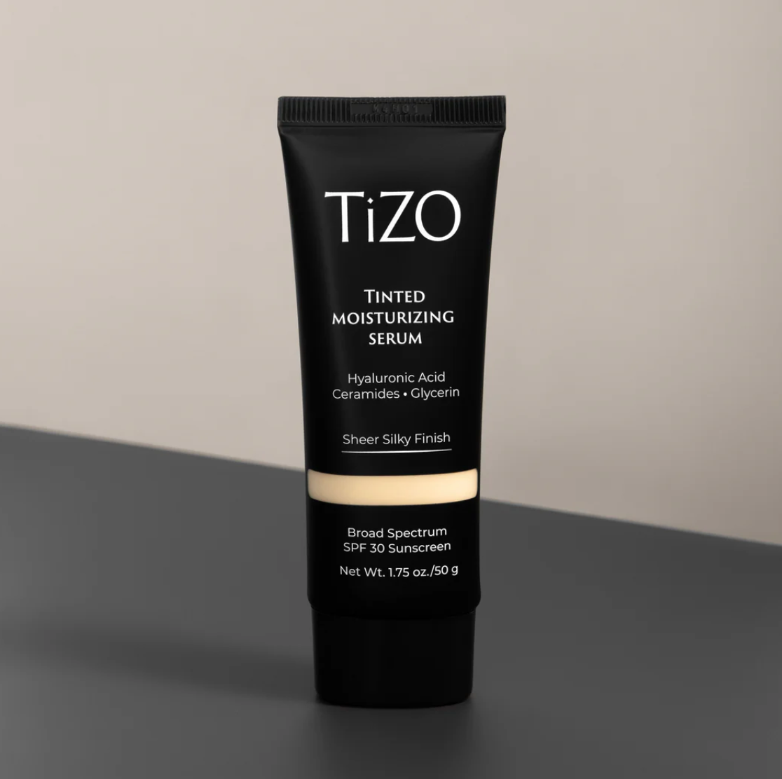 A tube of TiZO Tinted Moisturizing Serum with hyaluronic acid, ceramides, and glycerin, offering broad-spectrum SPF 30 sunscreen in a sheer finish.